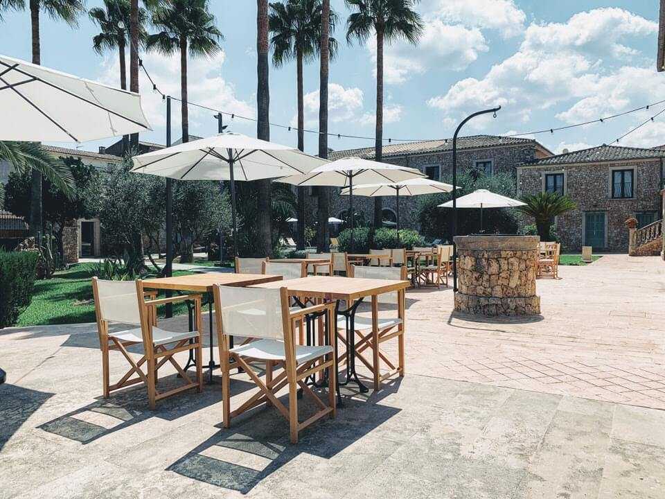 Gartenterrasse mit Palmen und Sonnenschirmen