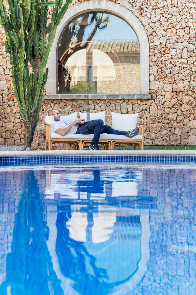 Pool, in dem sich ein Bogenfenster des Hauses spiegelt